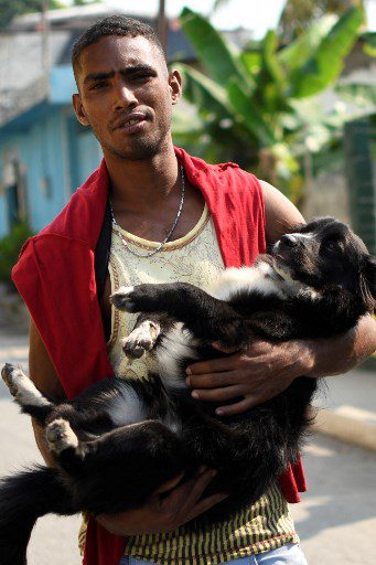 El migrante venezolano Gilberto Rodríguez posa con su perro llamado Negro afuera de la Casa del Migrante en Tecun Uman, Guatemala. 