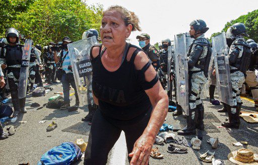 Se ve a una mujer migrante mientras miembros de la Guardia Nacional impiden el paso de migrantes que forman parte de una caravana que se dirige a la Ciudad de México, en una carretera en Tapachula, estado de Chiapas, México, el 1 de abril de 2022..