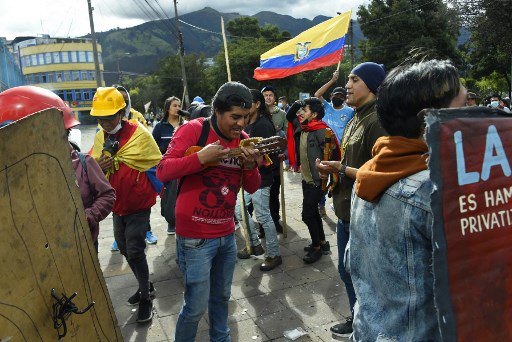 Manifestantes bailan y tocan música en los alrededores de la Asamblea Nacional en Quito el 25 de junio de 2022, ante una sesión parlamentaria convocada por legisladores de la oposición para una moción de censura contra el presidente Guillermo Lasso que se realizará en el marco de las protestas lideradas por indígenas contra el gobierno.