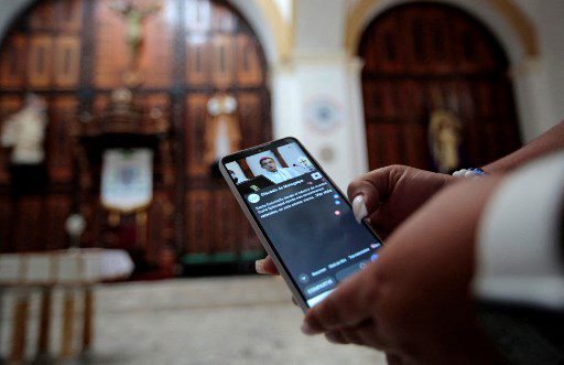 Una mujer observa la misa de Monseñor Rolando Alvarez a través de Facebook en la Catedral de Matagalpa en Matagalpa, Nicaragua, el 5 de agosto de 2022. 