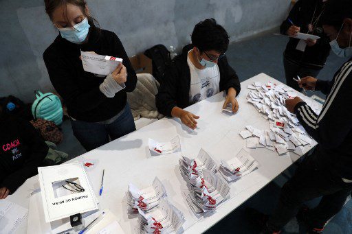 Los funcionarios electorales cuentan los votos después de que las urnas cerraron durante un referéndum para aprobar o rechazar una nueva Constitución, en el colegio electoral de Santiago, el 4 de septiembre de 2022.