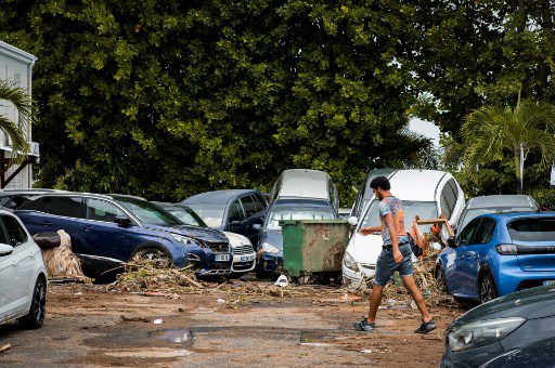 Un peatón pasa junto a autos superpuestos y escombros tras el paso del huracán Fiona en Goyave, en la isla francesa de Guadalupe, el 18 de septiembre de 2022. 
