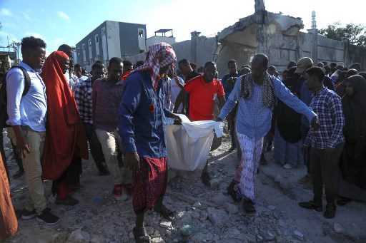 Los residentes llevan el cuerpo de una víctima en Mogadishu el 30 de octubre de 2022 después de que un coche bomba bombardeara el Ministerio de Educación .