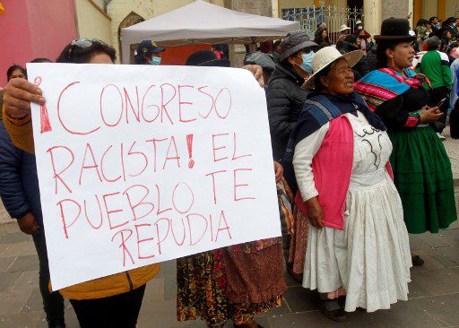 Un partidario del derrocado presidente Pedro Castillo sostiene un cartel que dice "¡Congreso racista! El pueblo te repudia" durante un mitin en la ciudad andina de Puno, Perú, contra la recién juramentada presidenta Dina Boluarte, el 8 de diciembre de 2022. 