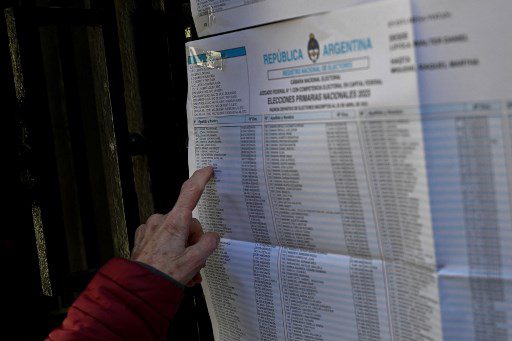 Una mujer revisa su nombre en las listas antes de votar en las elecciones primarias en un colegio electoral de Buenos Aires el 13 de agosto de 2023