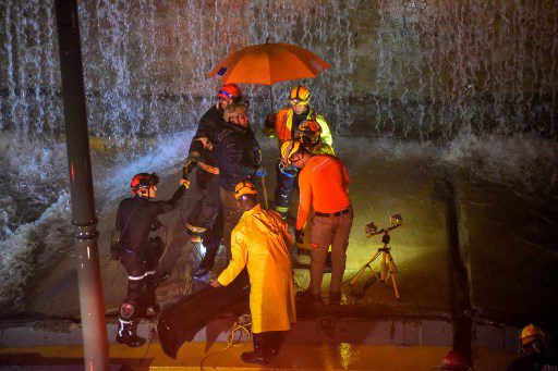 Los rescatistas buscan personas atrapadas debajo de un muro que se derrumbó sobre varios vehículos luego de fuertes lluvias en la avenida 27 de Febrero en Santo Domingo el 18 de noviembre de 2023.