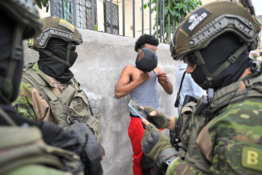 Miembros de las Fuerzas de Élite del Ejército inspeccionan a un hombre y verifican su identidad durante una patrulla en las calles de Carapungo, un barrio popular en el norte de Quito, el 11 de enero de 2024, ya que Ecuador se encuentra en un 